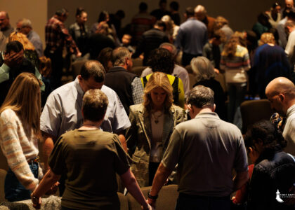 Image of people in a congregation praying with one another.